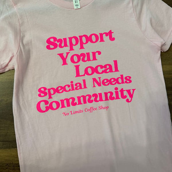 Pink t-shirt with "Support Your Local Special Needs Community" in bright pink text.