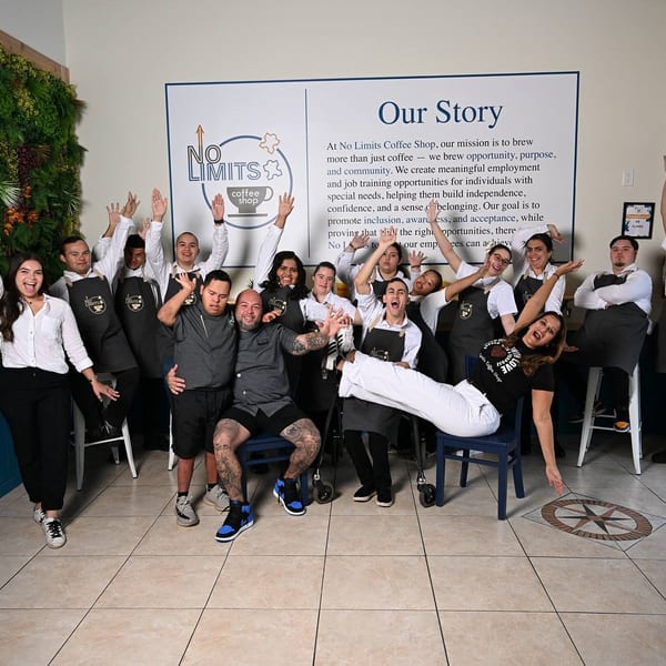 No Limits Coffee Shop staff, including individuals with special needs, happily pose in their aprons.